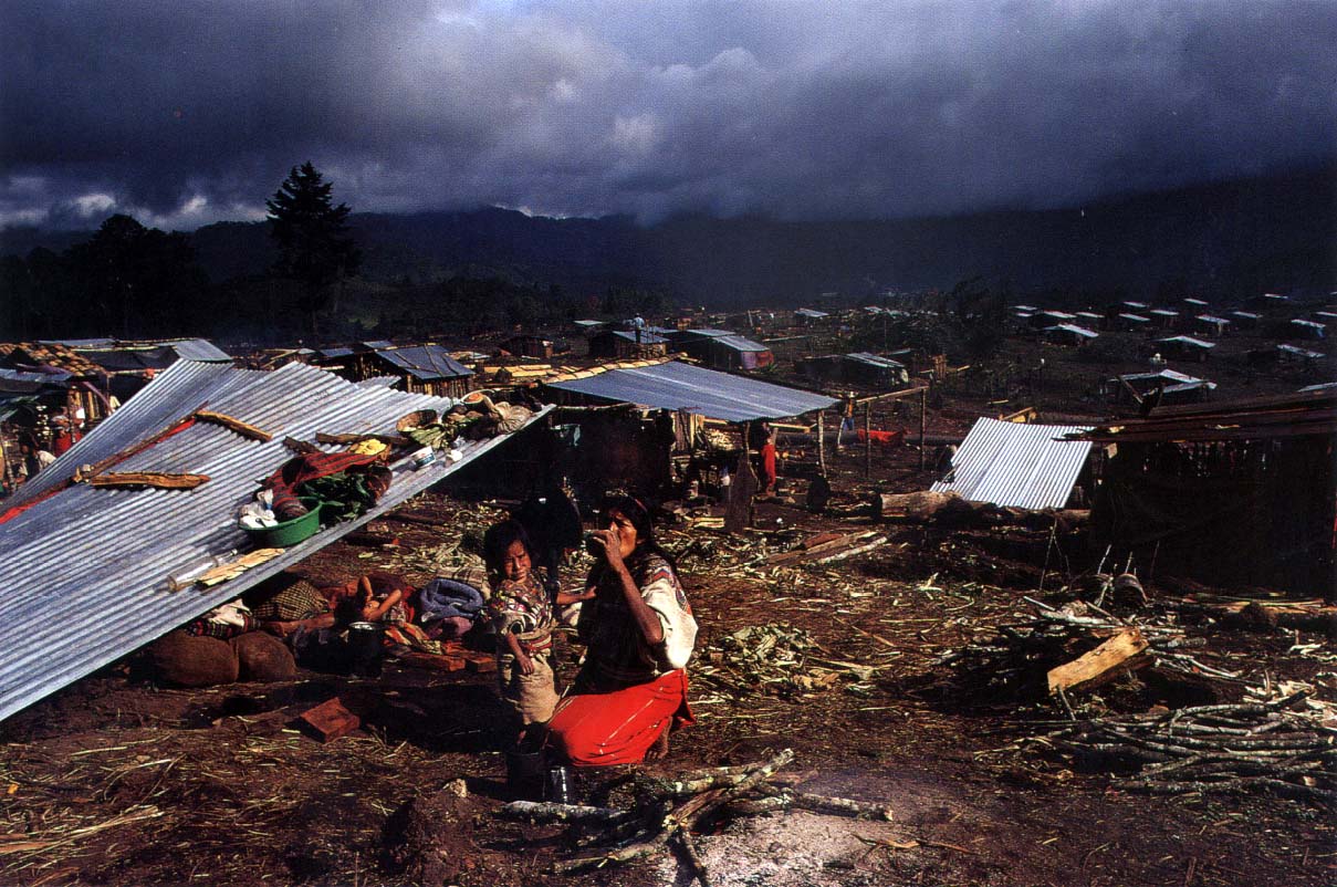 Ixil woman and child refugee drink water while sitting in the New Life refugee camp near Nebaj, Quiché.